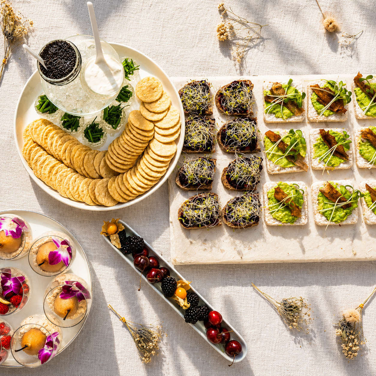 Luxury vegan catering spread with Ayvee vegan caviar, plant-based appetizers, artisan crackers, avocado bites, desserts, and fresh berries in warm natural lighting.